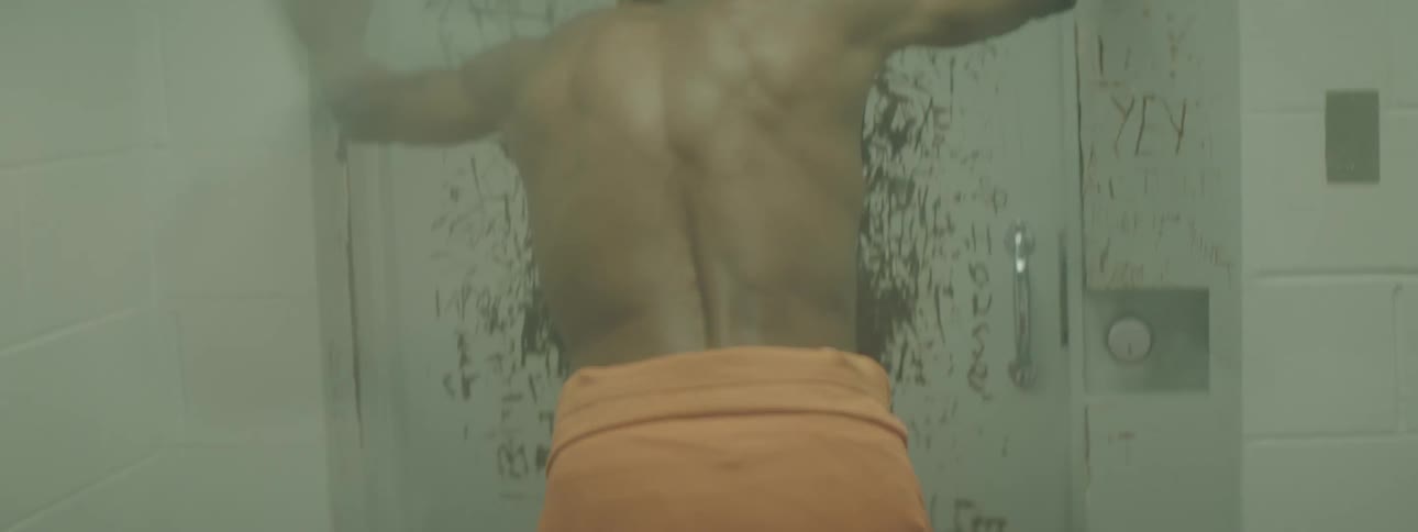 A man leans against a prison door
