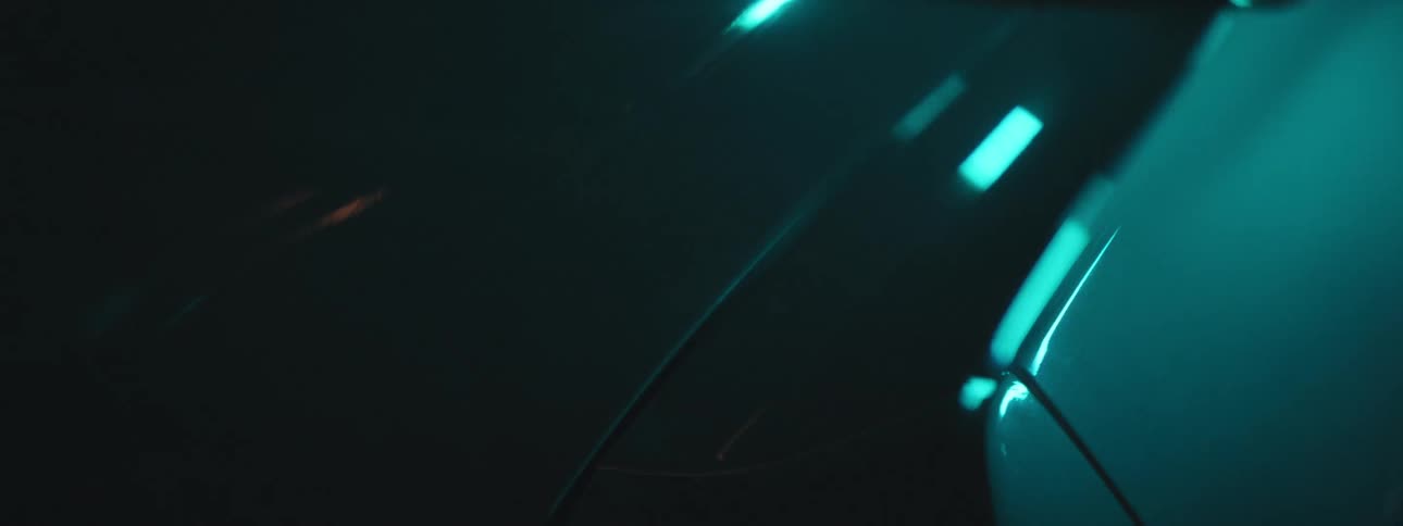 Abstract closeup of section of a shiny new white car with green lighting and shadow wipe reveal and conceal
