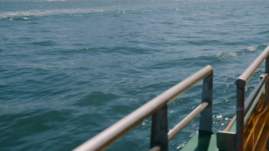 Small waves on the calm ocean surface seen from a moving boat at daytime
