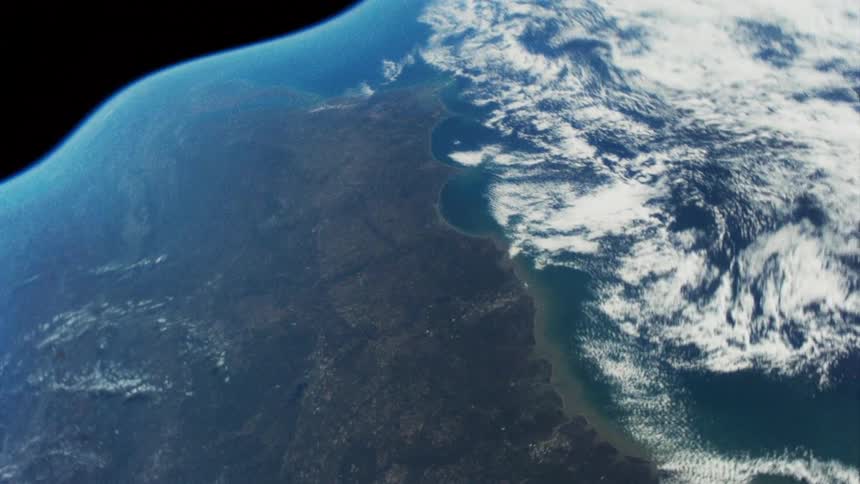 Clouds and terrain undulate on surface of warping earth