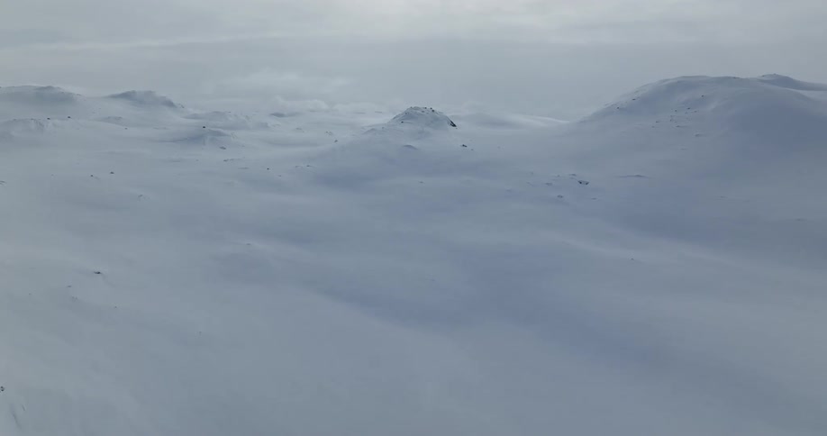 Aerial view of snow covered mountains during midday