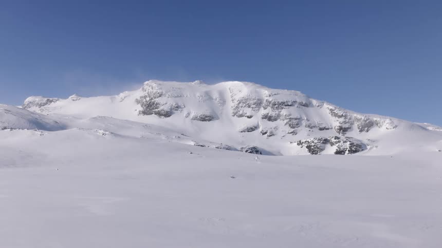 A snow covered mountain is displayed at midday