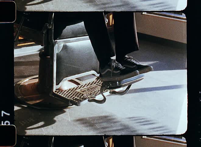 A persons feet as they get into a chair with a foot rest