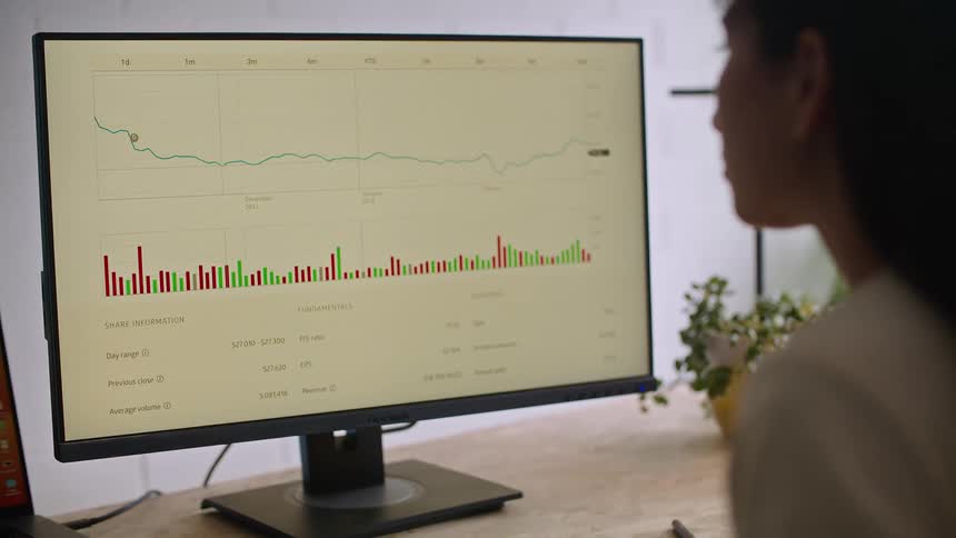 A woman views a chart on a computer in an office during the day
