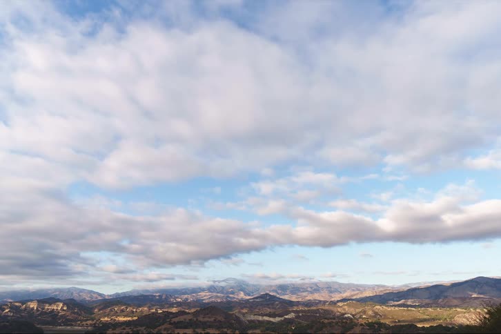 Clouds pass over a mountainous countryside during the day