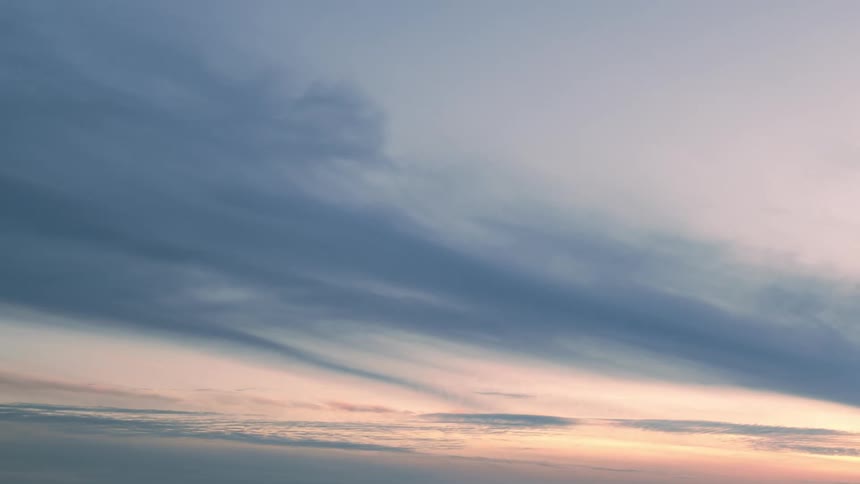 The thick clouds move across the sky and turn darker as the sun is setting
