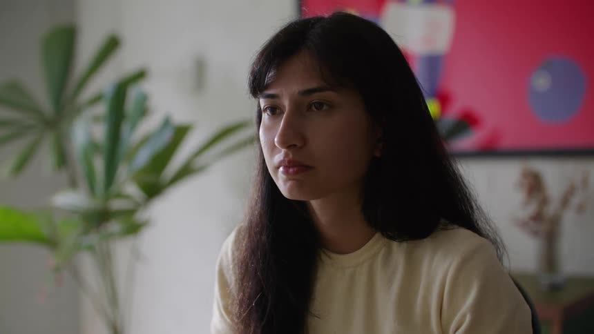 A young woman is inside of her office and using her computer