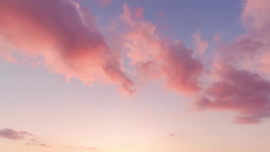 Sunlight shines on clouds as they turn pink moving across the sky as the sun sets