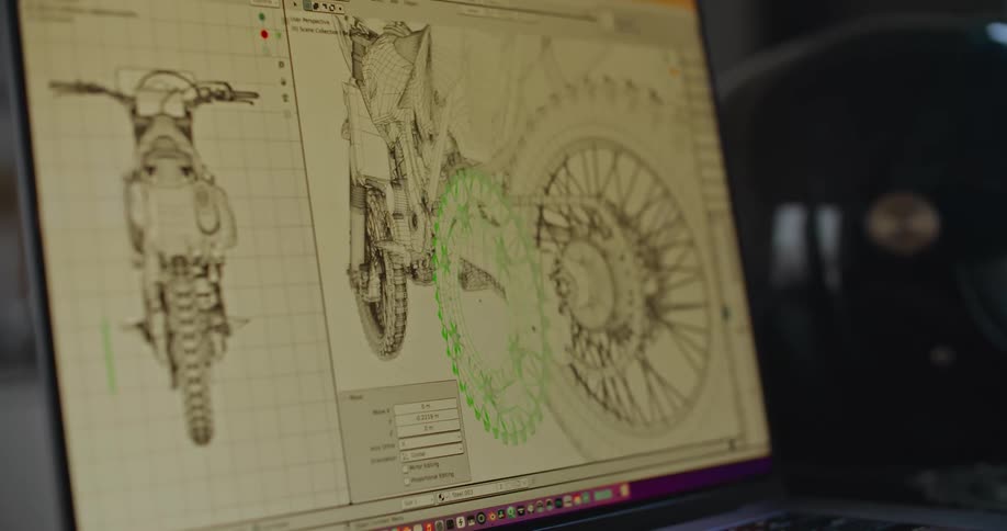 Employee manipulates image of motorcycle gear on laptop screen