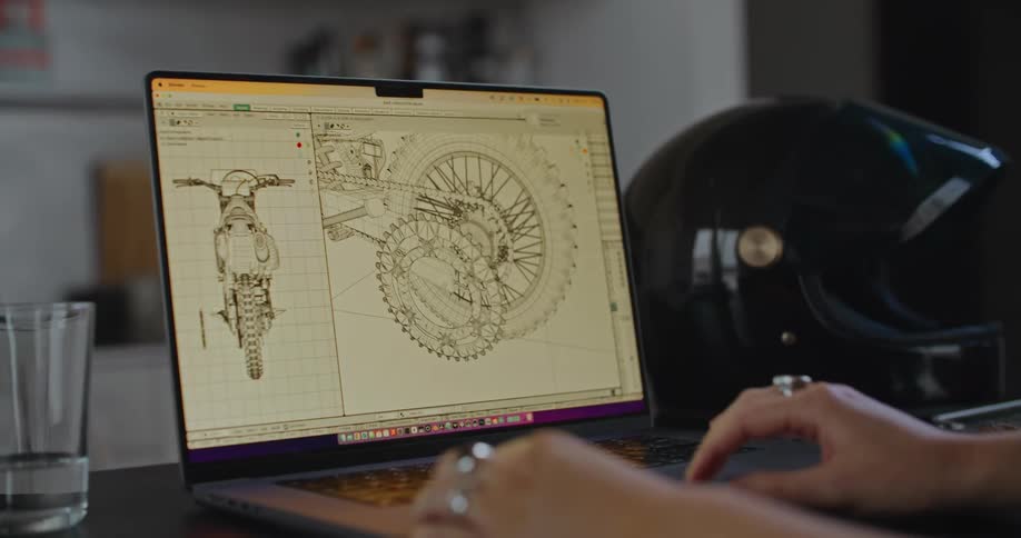 A woman hands using a laptop keyboard while using a program on her computer to adjust drawings on the screen