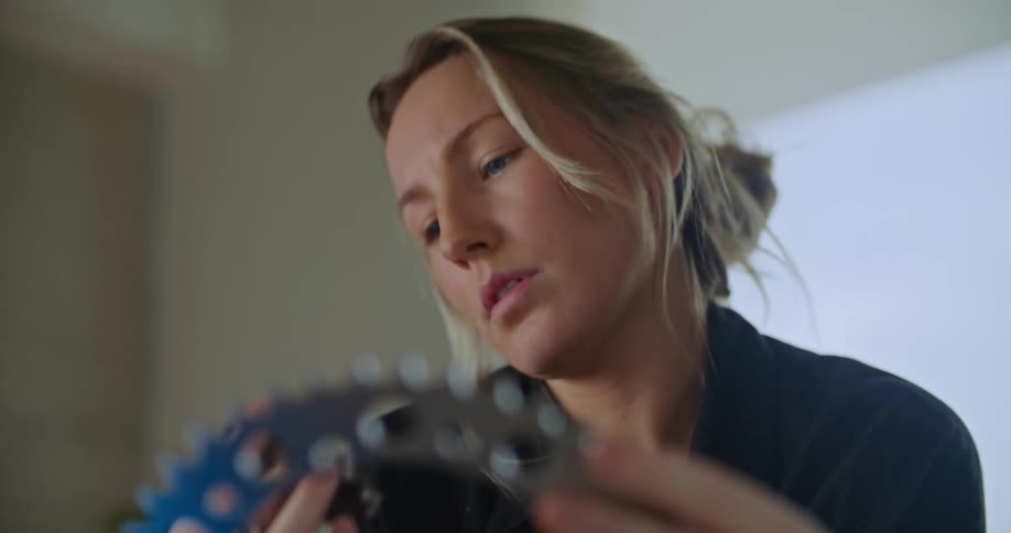 Woman in office examines two different sized gears