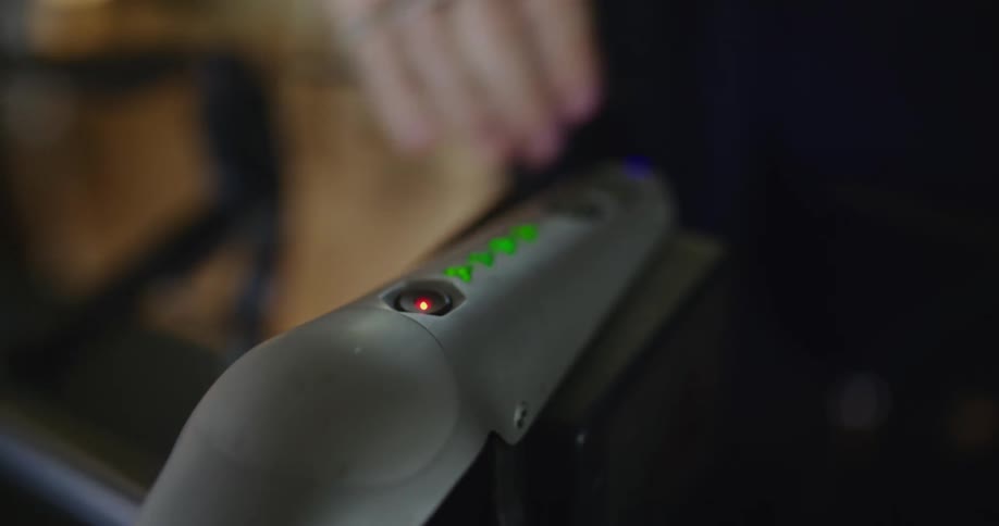 Close up of the hand of a woman pressing the red turn on button on a drone