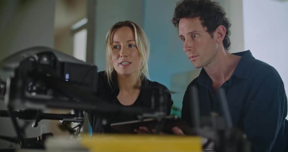 Two people are talking to each other as they look at the video camera