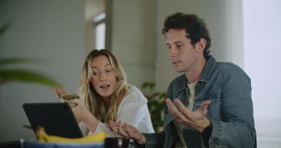 Man and woman are talking and looking at their laptop
