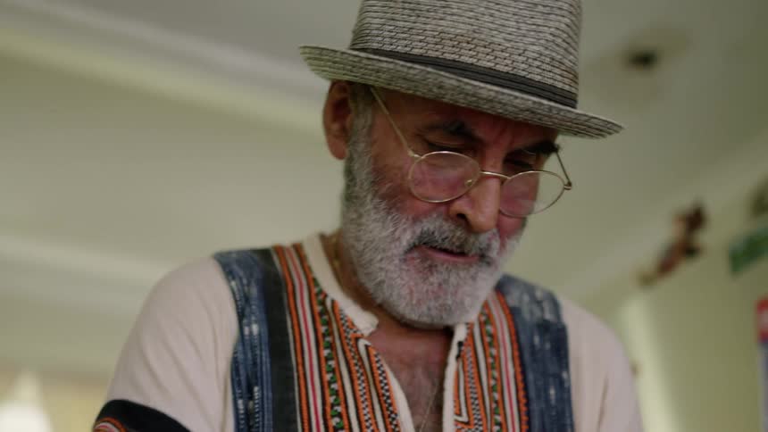 An elderly man is inside of his house in the day time