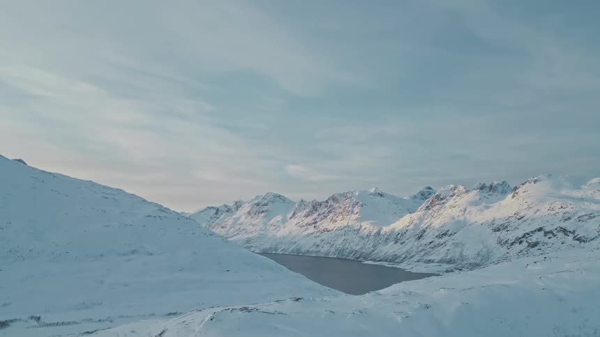 A river between mountain ridges in a snowy covered countryside during the day