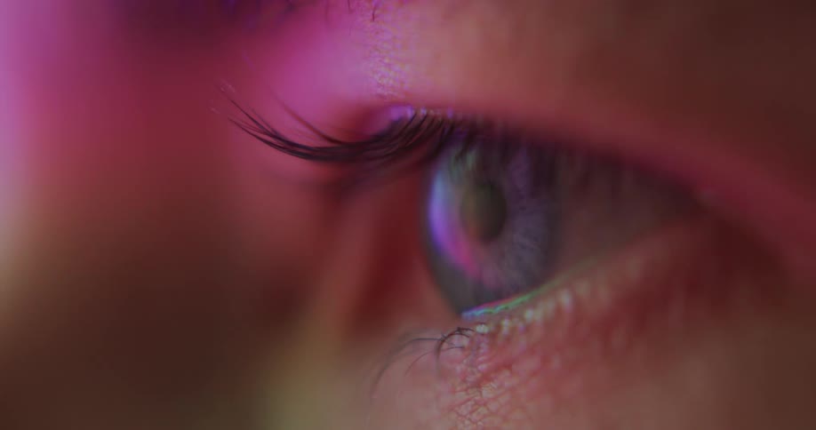 An extreme close up of a persons eyeball blinking and looking around