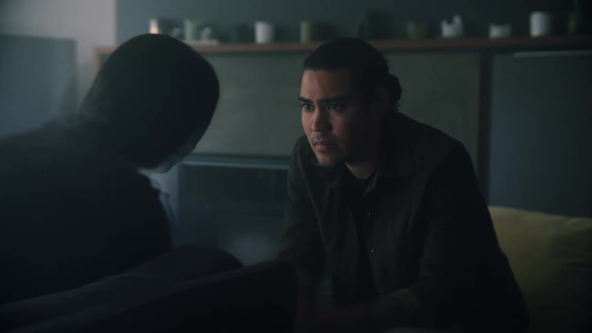 A man is sitting down talking to someone and he looks upset
