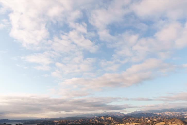 Clouds pass over a mountainous countryside during the day