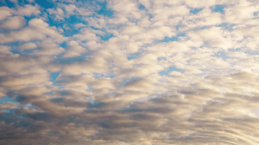 Time lapse of rolling clouds changing colors at evening