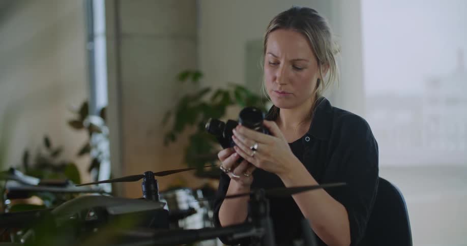 A young woman is holding a camara in the day time