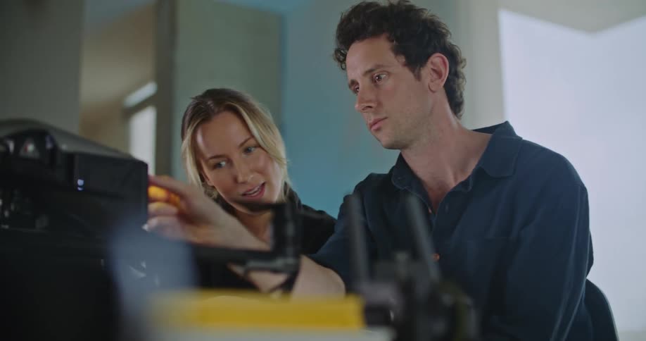 Man and woman are talking and looking at a machine
