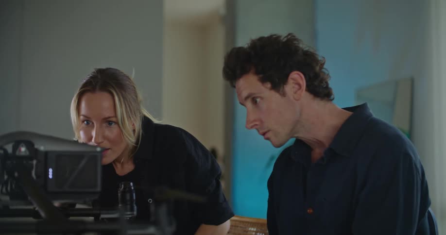 Two people on a room have a lively conversation while configuring a drone over a table