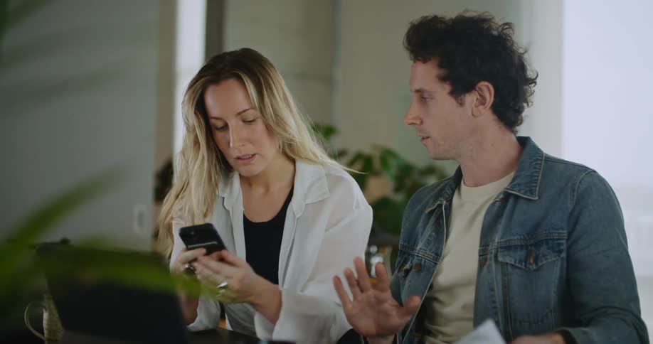 Couple reading instructions together while searching on the phone and laptop