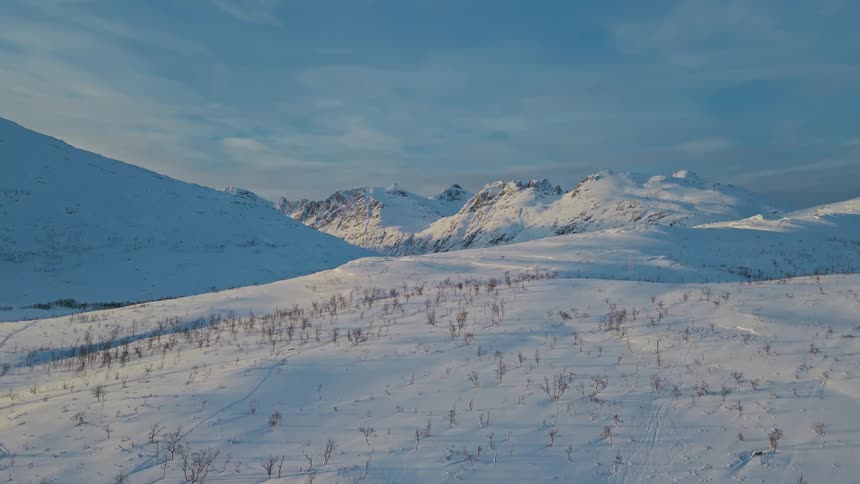 Aerial view of snow covered mountains is displayed