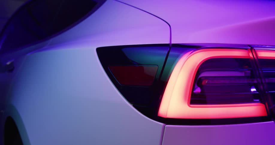 It is a portrait of an electric car and someone is unplugging it