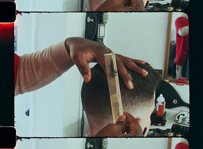 Aman is giving another guy a hair cut in the barber shop