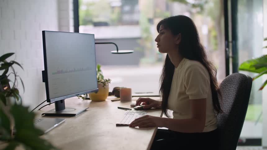 A young woman uses a computer in an office during the day