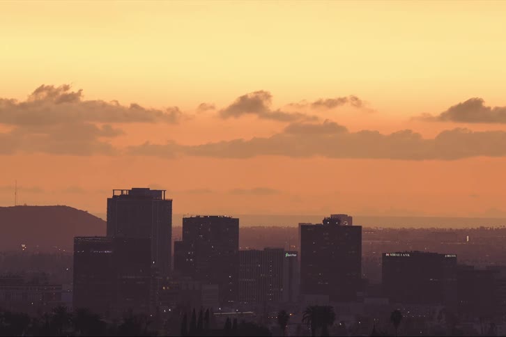 Aerial view of a city during sunset is displayed