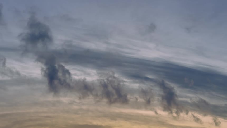 Sunlight shines through dense clouds in the sky