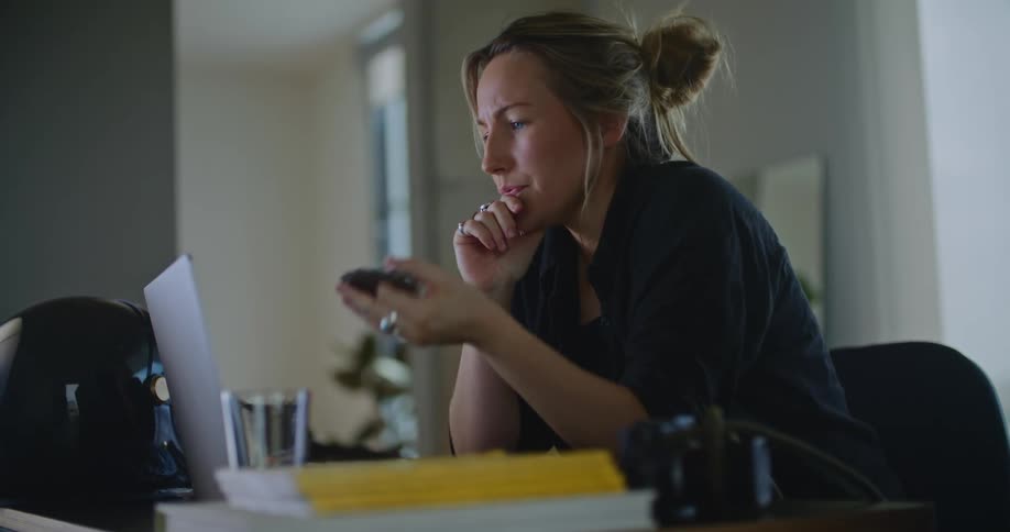 Woman holding a gear in her hands searches on a laptop in her office