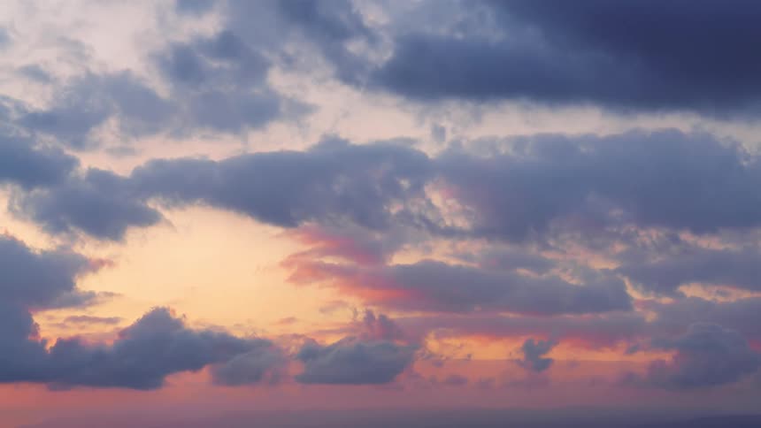 A time lapse of the sky changing colors for daylight to dusk as clouds roll through