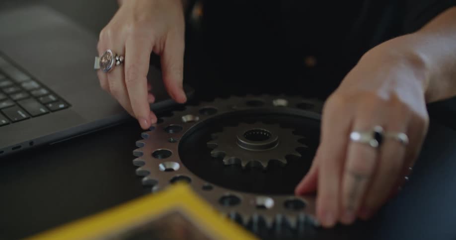 Woman is sitting at a desk and picking up metal