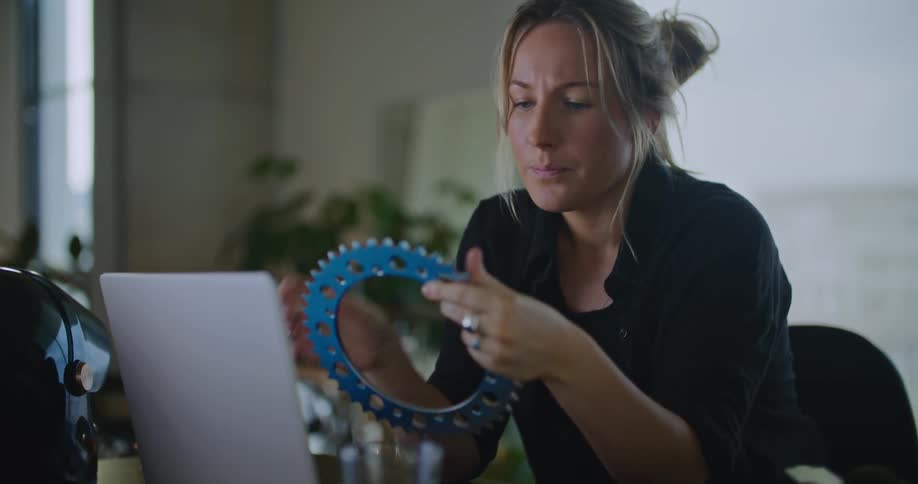 A woman looking at parts sitting in front of a laptop
