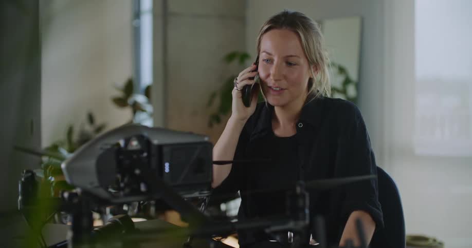 A woman is smiling and talking on her phone