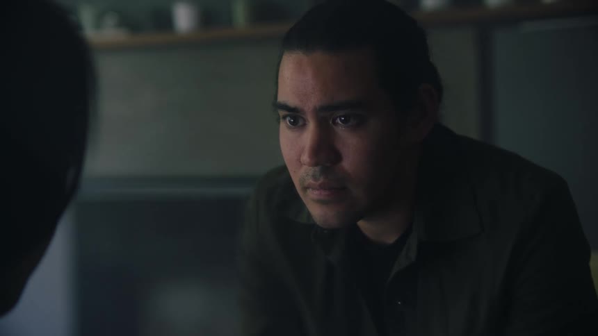 An up close of a mans face as he sits looking sad and staring in front of him