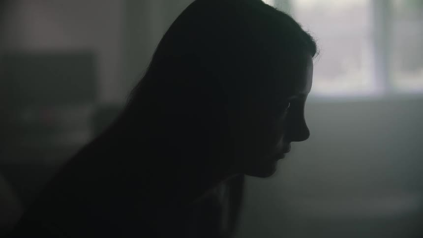 A woman is sitting by herself in a room