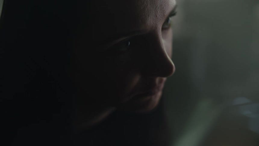 The view is of a young woman sitting down inside of her house