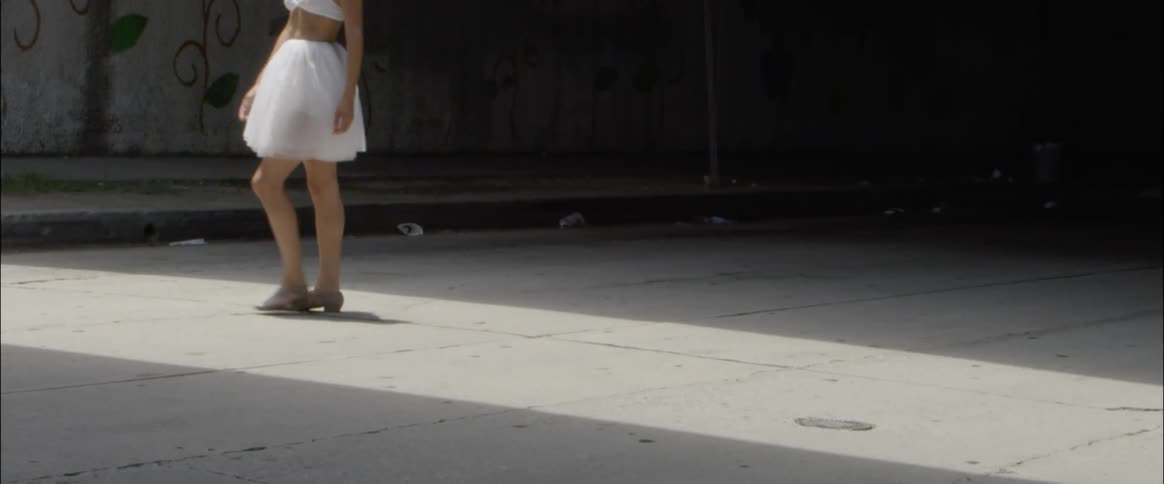 A ballet dancer walks on the street