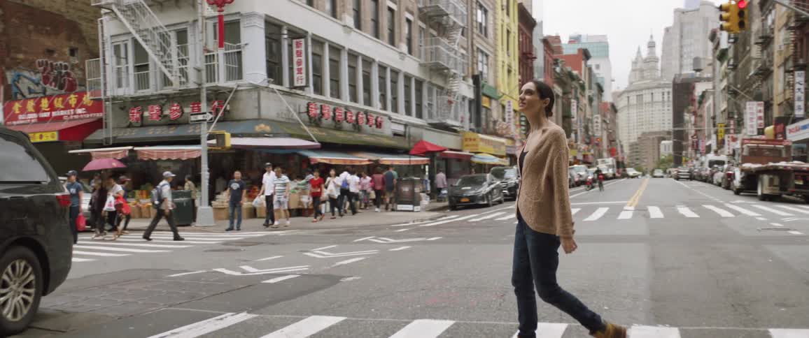 Woman walking across busy crosswalk