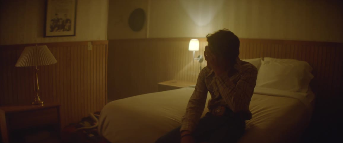 A man lays back on a hotel bed