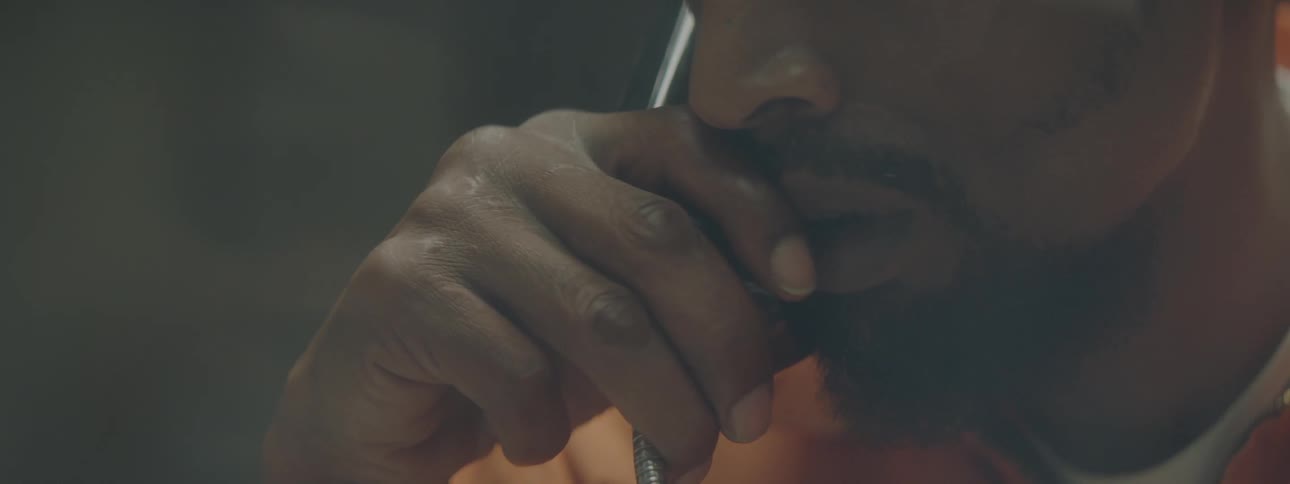 A man in an orange suit holds a phone