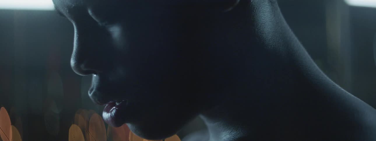 A man with his eyes closed in a dark room