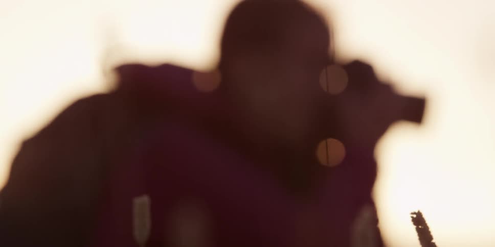 Image coming into focus of a man taking pictures outside