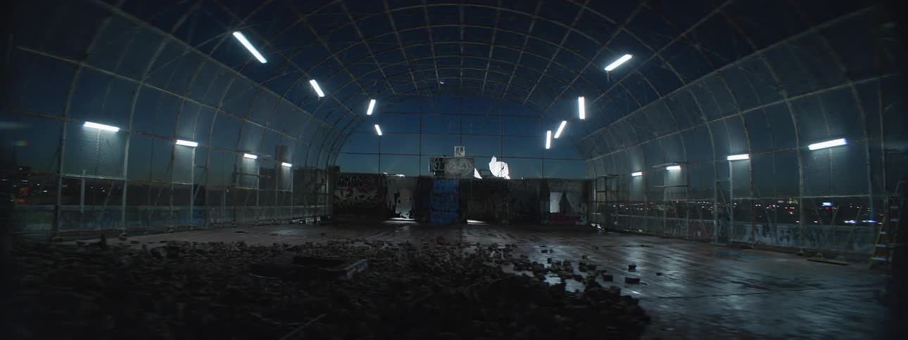 A building with dirt on the floor and lights swaying on the ceiling