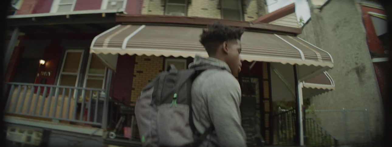 A man walks down the street dribbling a basketball